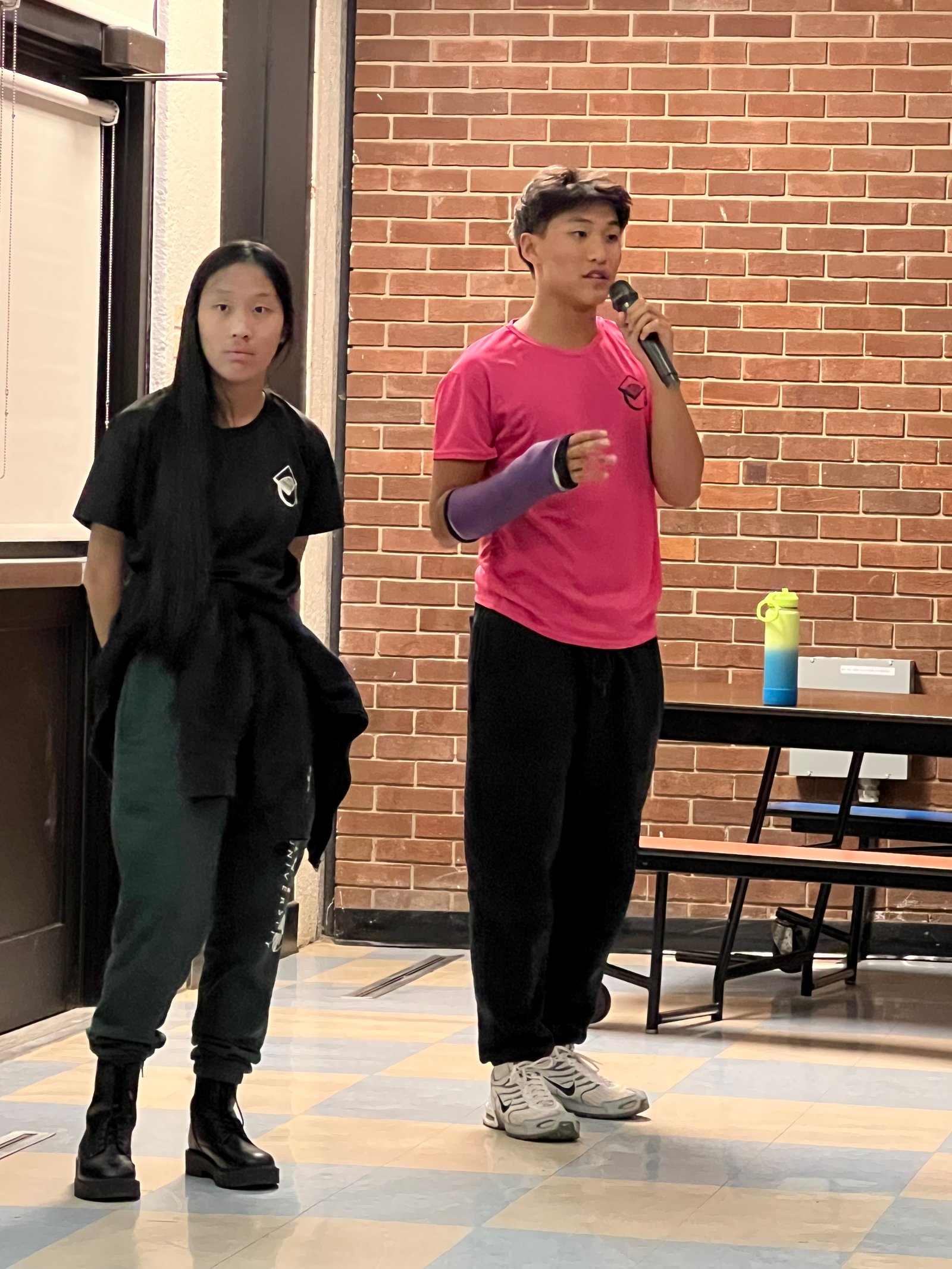 Student speaking into a microphone during a Scuola IB presentation.